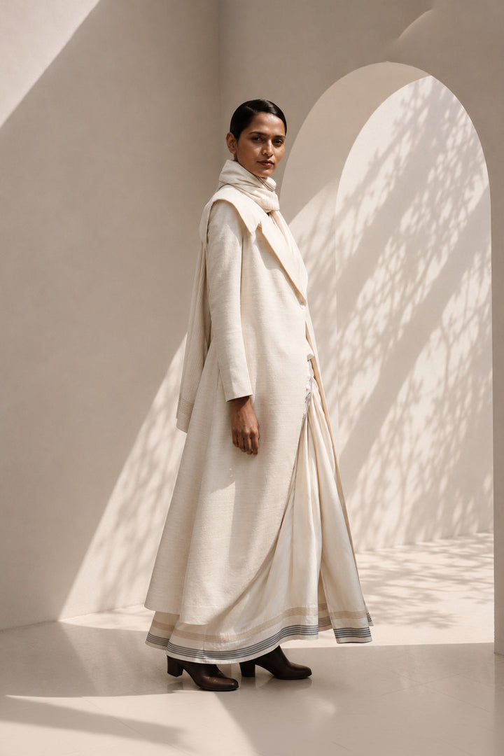 Ivory ensemble featuring oversized lapel collar, structured fit and fluid drape.