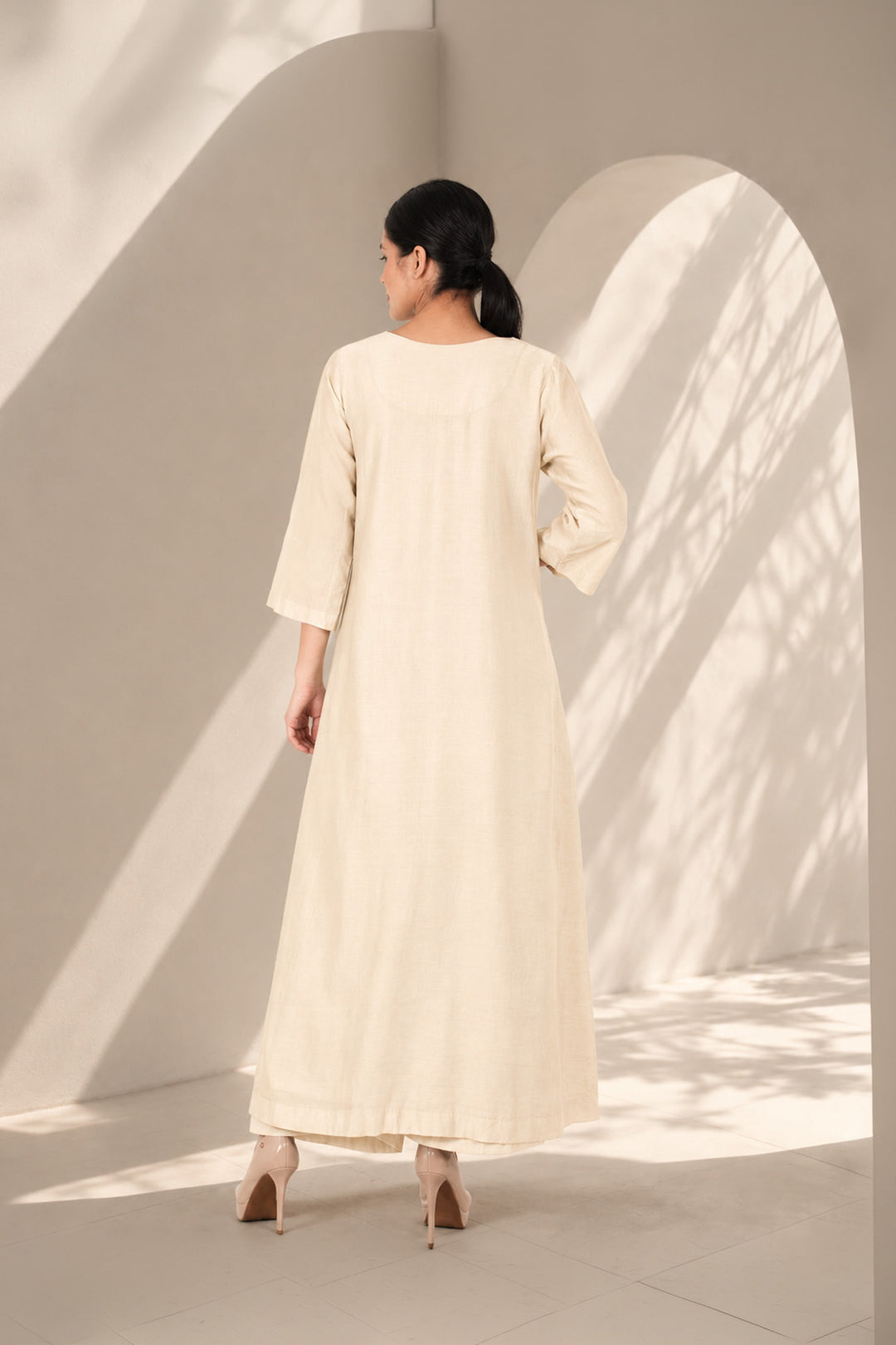 Ivory A-line dress featuring classic round neckline &amp; adorned with intricate floral embroidery.