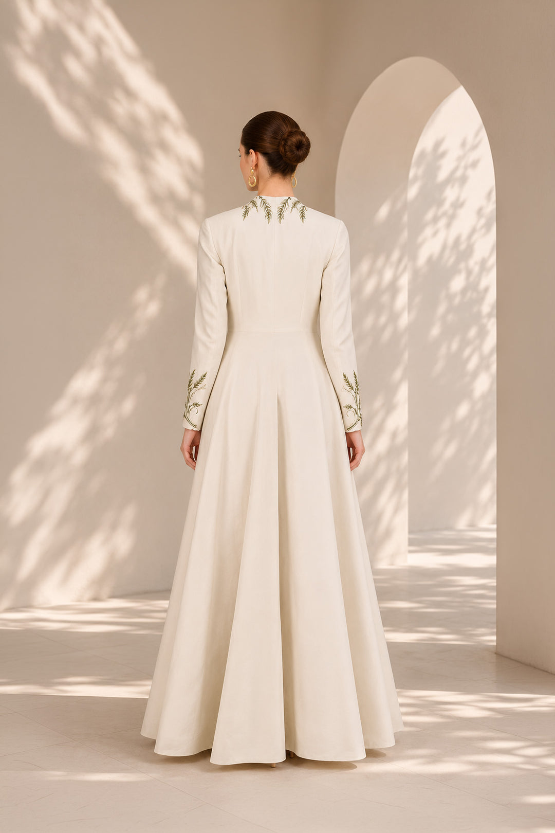 Ivory embroidered gown featuring a dramatic deep V-neckline, full-sleeves with embroidered cuffs, concealed side pockets.