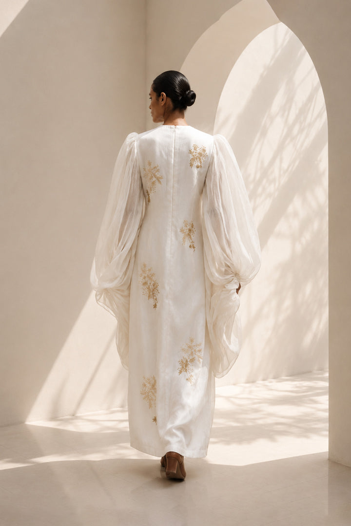 Ivory statement dress featuring dramatic sheer balloon sleeves and delicate botanical embroidery.