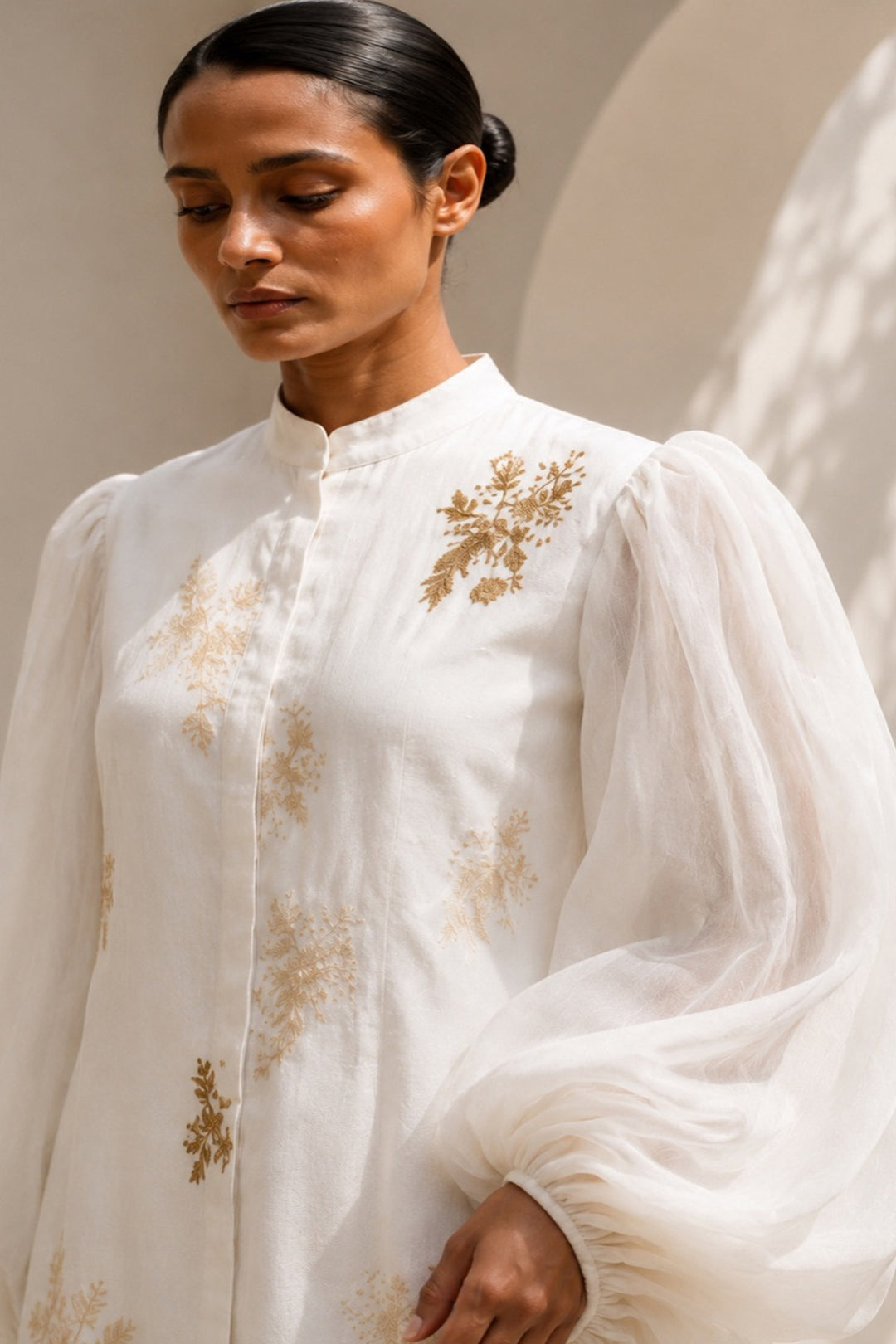 Ivory statement dress featuring dramatic sheer balloon sleeves and delicate botanical embroidery.