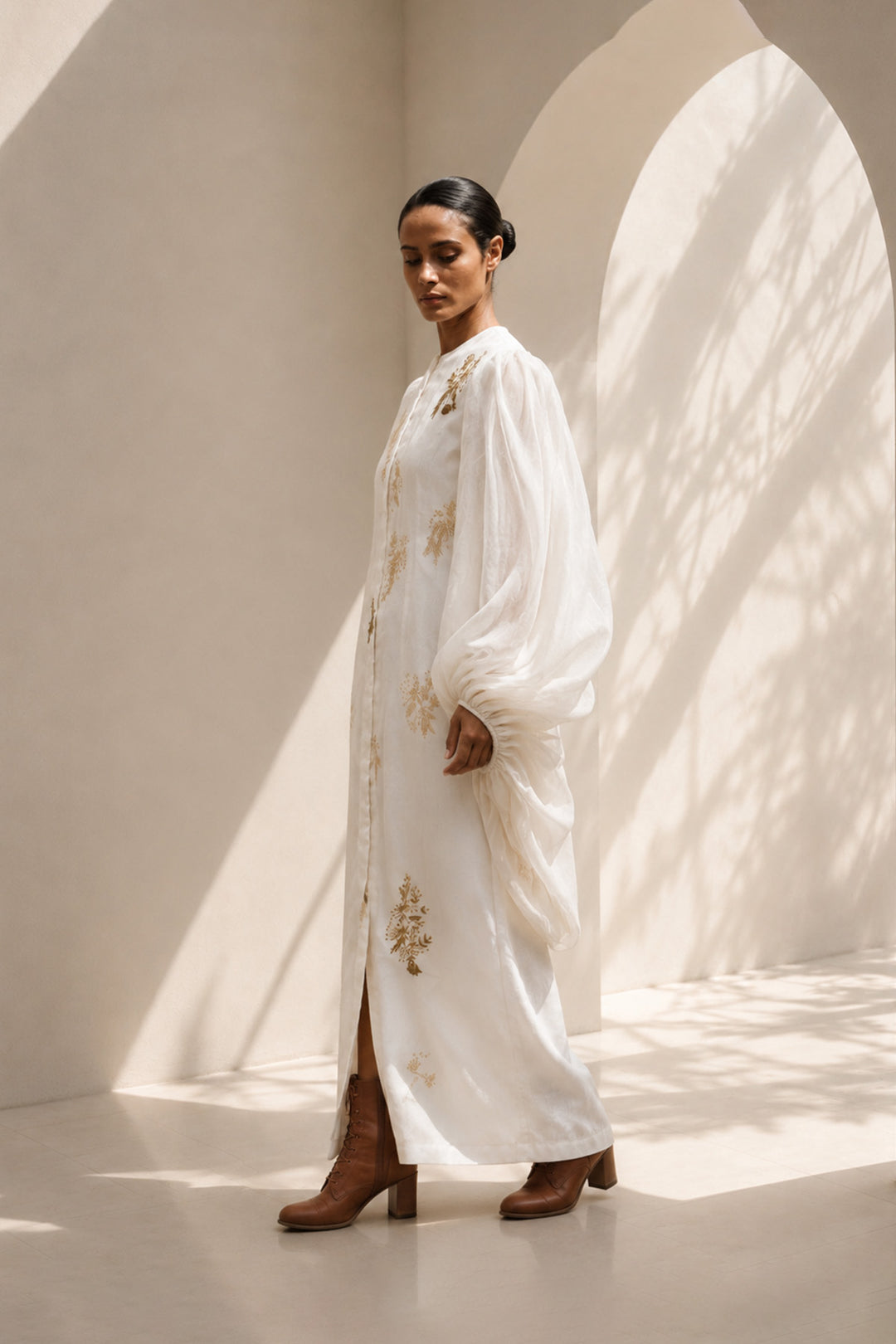 Ivory statement dress featuring dramatic sheer balloon sleeves and delicate botanical embroidery.