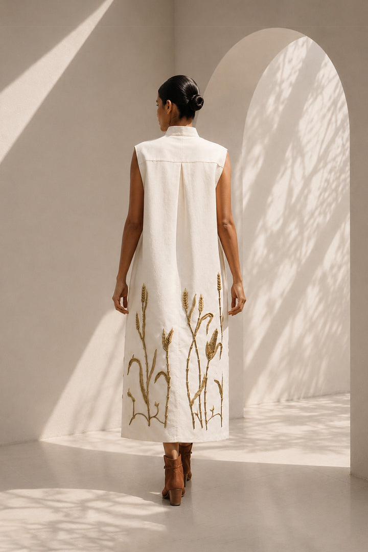 Ivory modern sleeveless statement dress featuring sculptural pocket detailing and intricate wheat-inspired embroidery.