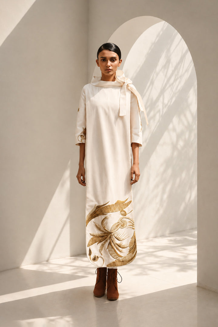 Ivory shift dress adorned with bold botanical artwork and a sculptural bow neckline.