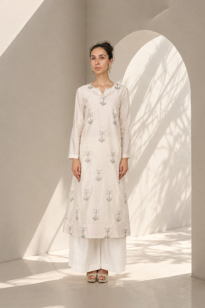 Ivory kurta set adorned with delicate motifs, elegant notch neckline, straight silhouette with a relaxed fit paired with wide-leg trousers.