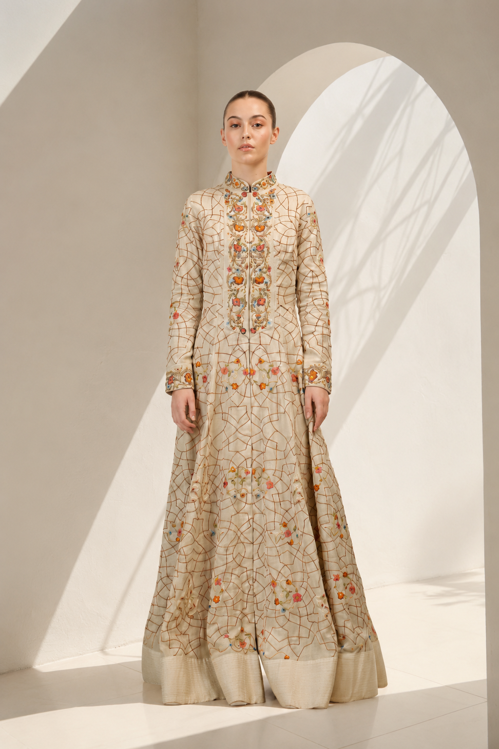 Woman wearing a long, embroidered dress in a minimalistic setting
