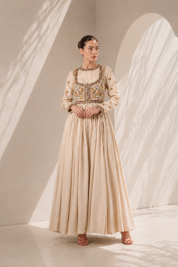 Ivory embroidered Anarkali featuring an intricately embellished yoke, sheer neckline detailing, and a flowing gathered silhoutte.