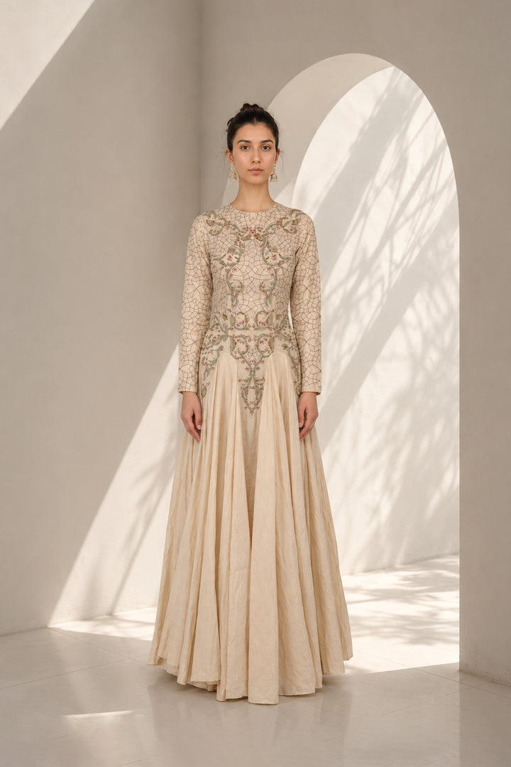 Ivory embroidered gown adorned with intricate floral embroidery, featured with elegant round neckline, fitted bodice, full-length fitted sleeves.