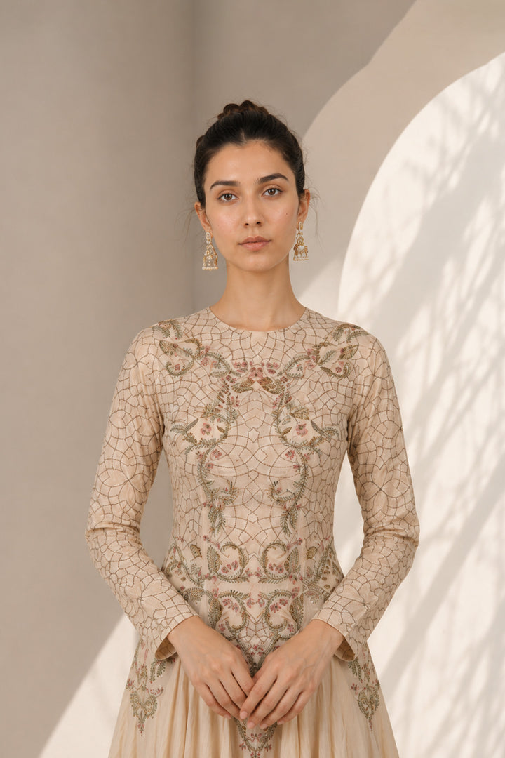 Ivory embroidered gown adorned with intricate floral embroidery, featured with elegant round neckline, fitted bodice, full-length fitted sleeves.