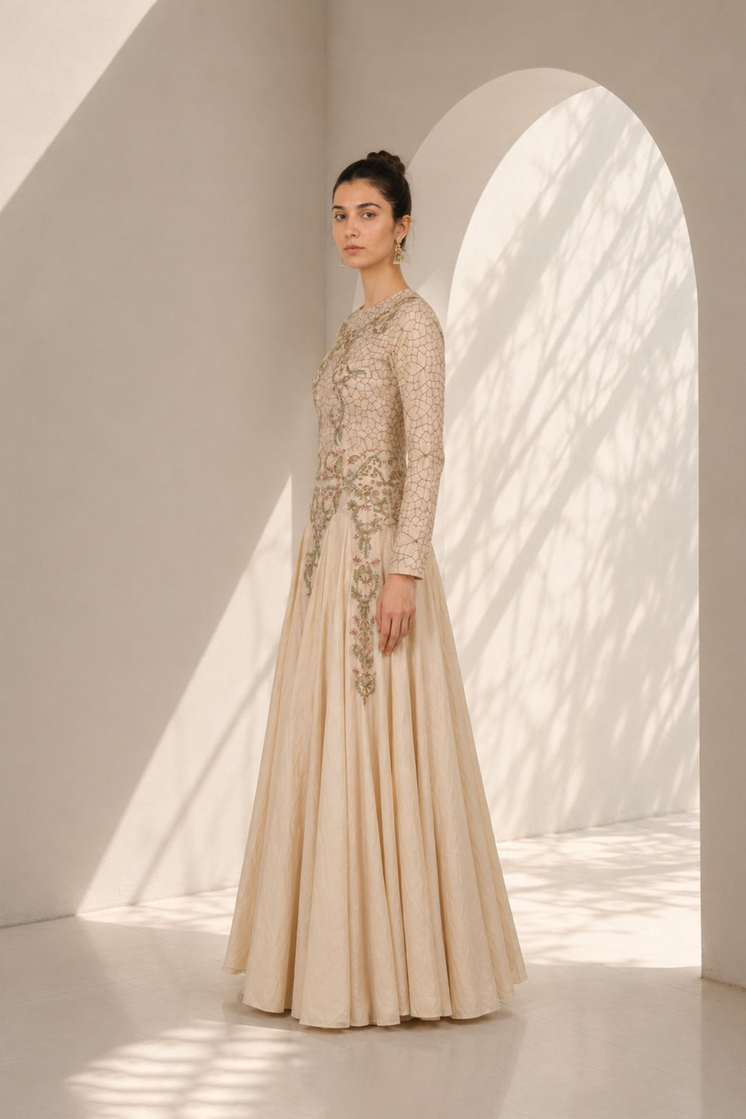 Ivory embroidered gown adorned with intricate floral embroidery, featured with elegant round neckline, fitted bodice, full-length fitted sleeves.