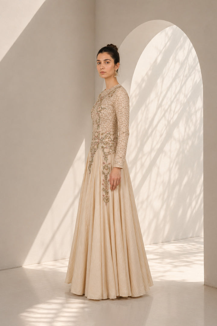 Ivory embroidered gown adorned with intricate floral embroidery, featured with elegant round neckline, fitted bodice, full-length fitted sleeves.