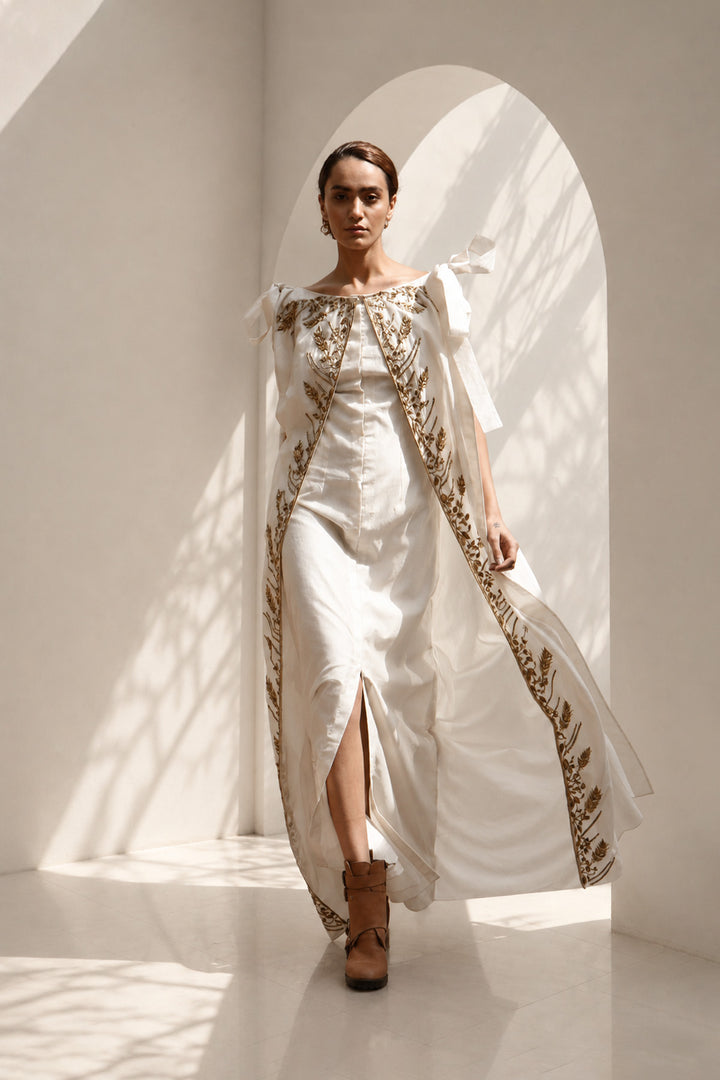 Ivory draped gown layered with a flowing embroidered cape