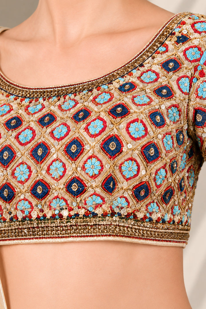 Ivory lehenga set featuring boat neckline blouse with elbow-length sleeves &amp; adorned with inrticate multicolor embroidery, paired with richly embellished skirt &amp; sheer dupatta.