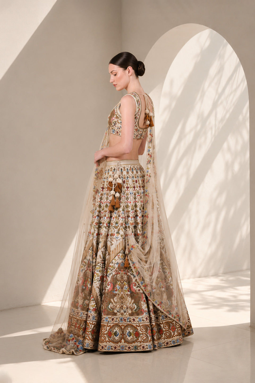Ivory lehenga set featuring sleeveless V-neck blouse with floral embroidery, a statement flared skirt with intricate embroidery on it and vibrant sheer dupatta.