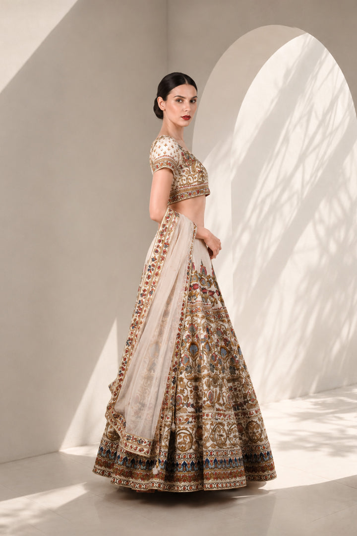 Ivory embroidered lehenga set featuring intricately embroidered blouse with scoop neckline and short sleeves, full flared lehenga paired with sheer dupatta.