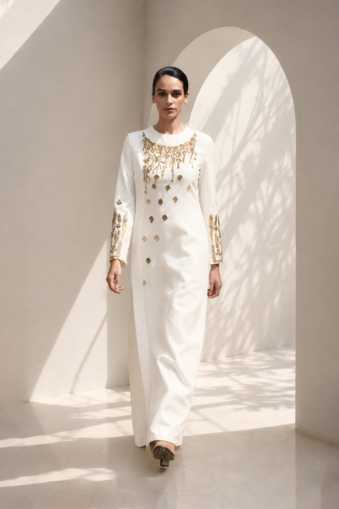 Ivory column dress adorned with delicate wheat-inspired embroidery, combining minimalist elegance.
