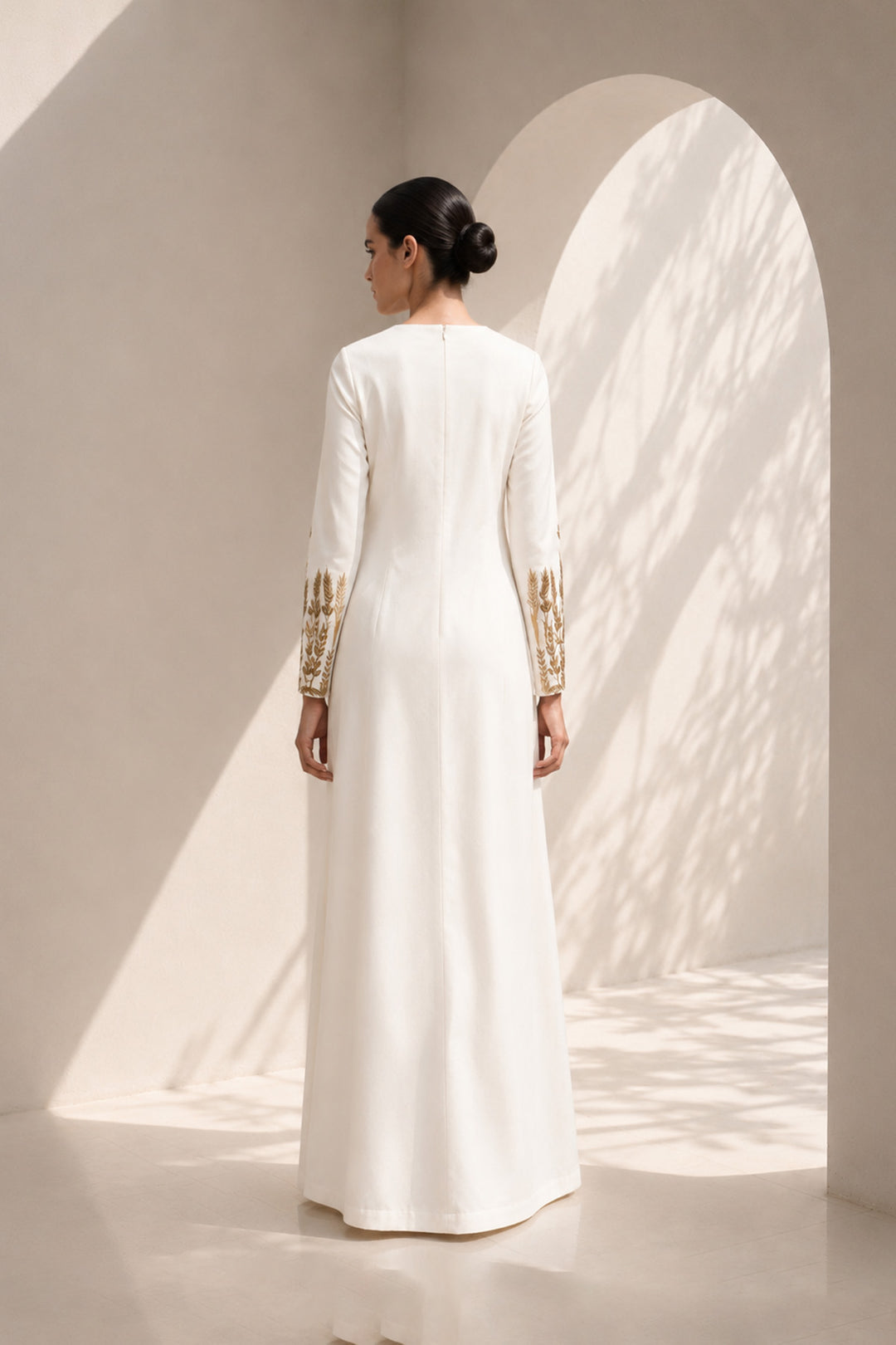 Ivory column dress adorned with delicate wheat-inspired embroidery, combining minimalist elegance.