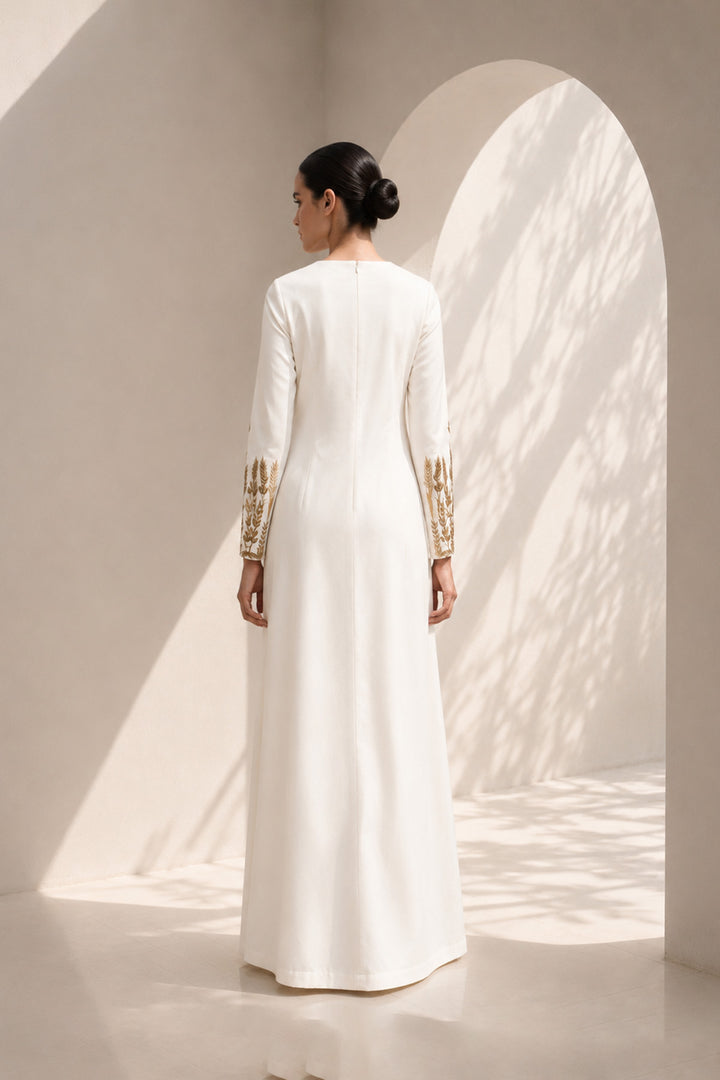 Ivory column dress adorned with delicate wheat-inspired embroidery, combining minimalist elegance.