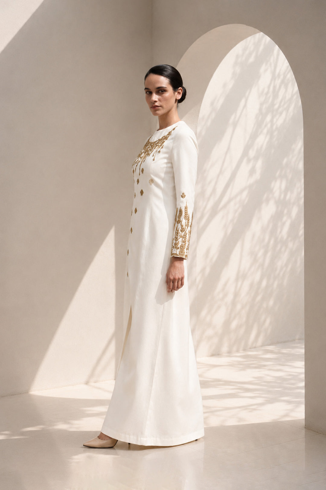 Ivory column dress adorned with delicate wheat-inspired embroidery, combining minimalist elegance.