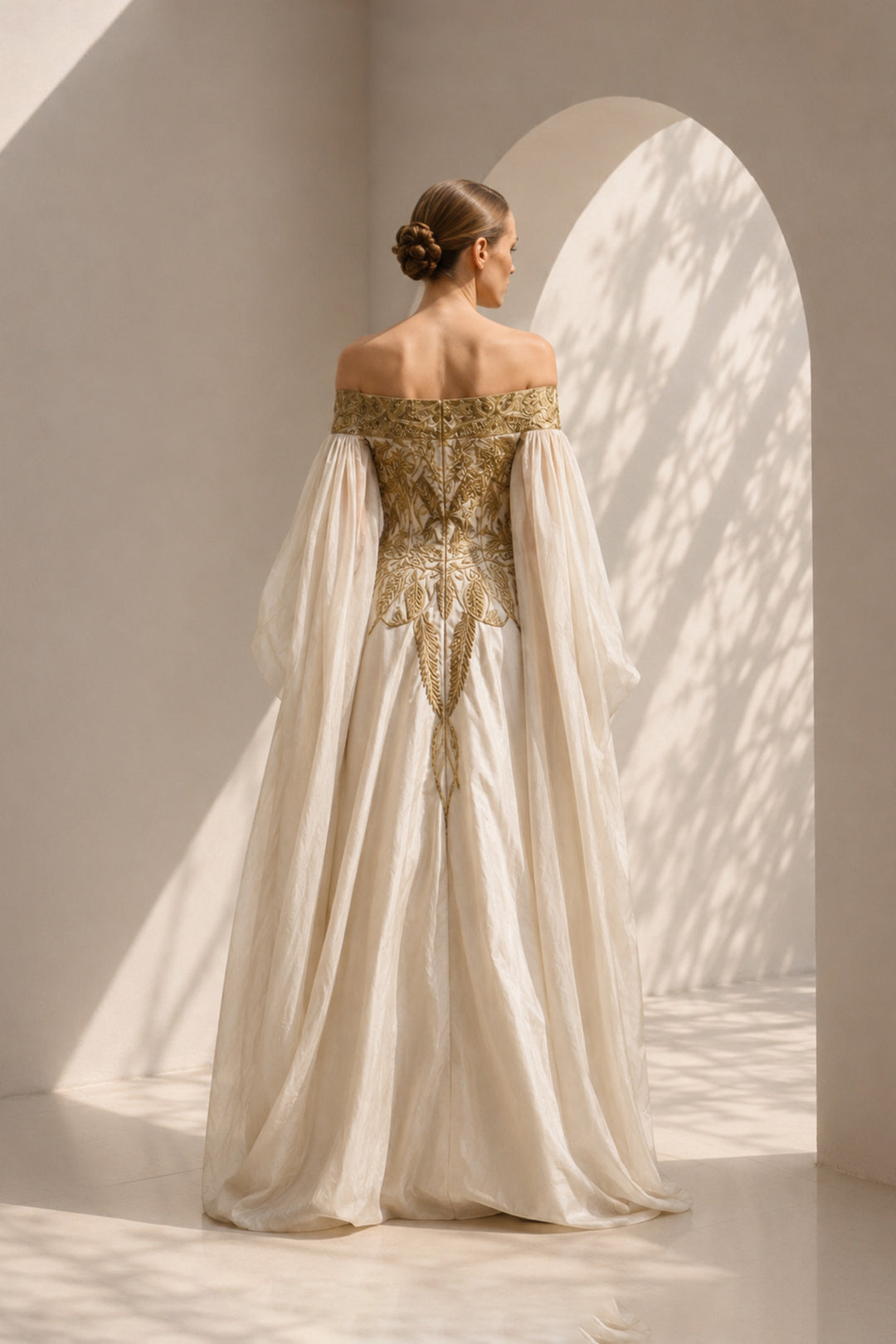 Ivory statement gown featuring intricate embroidery, an off-shoulder neckline, and dramatic sheer sleeves.