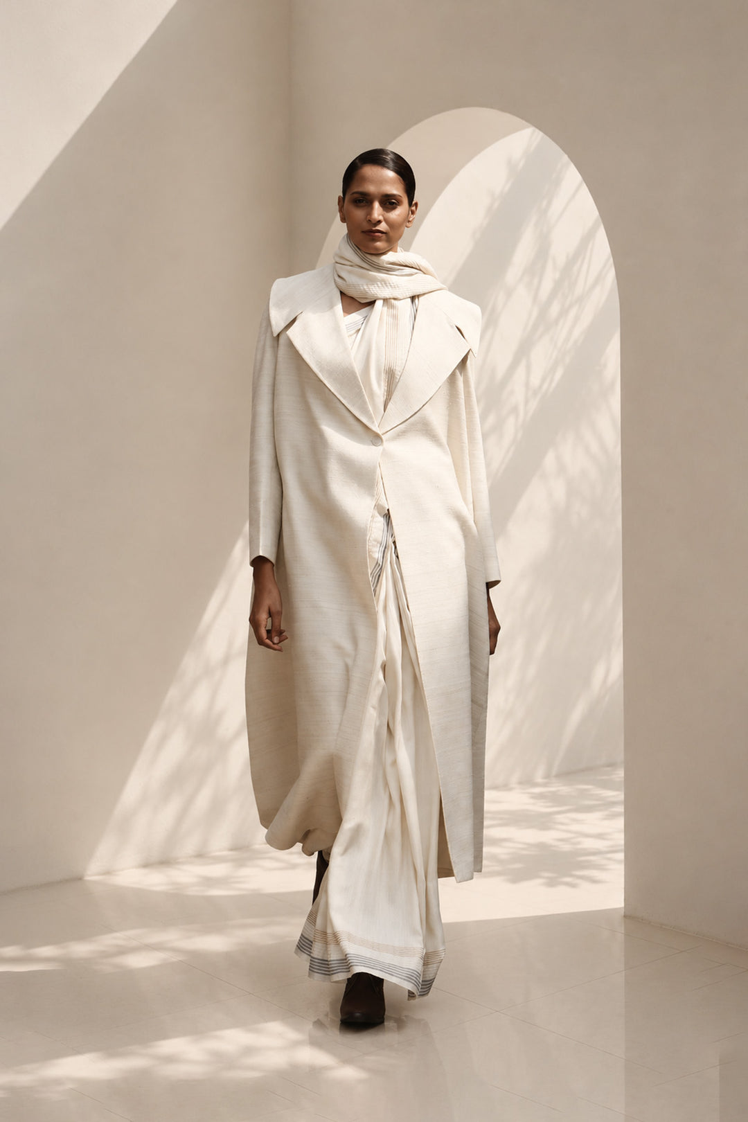 Ivory ensemble featuring oversized lapel collar, structured fit and fluid drape.
