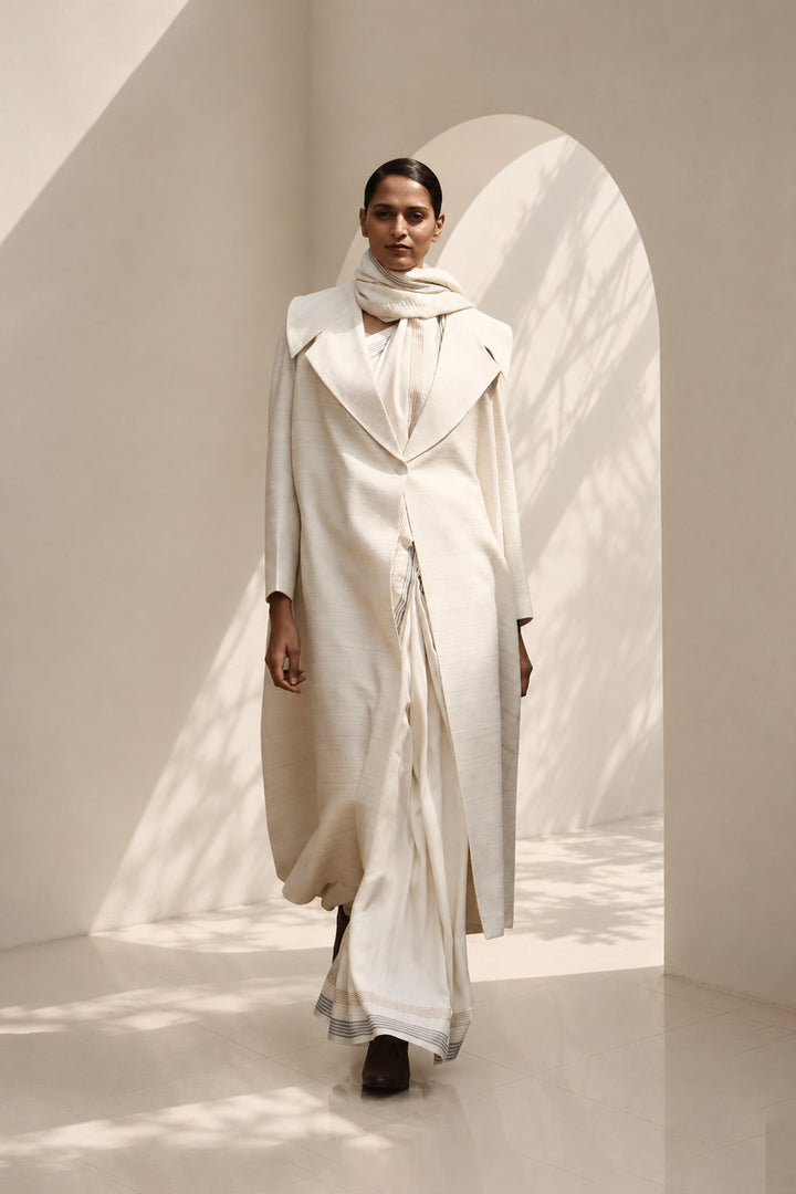 Ivory ensemble featuring oversized lapel collar, structured fit and fluid drape.