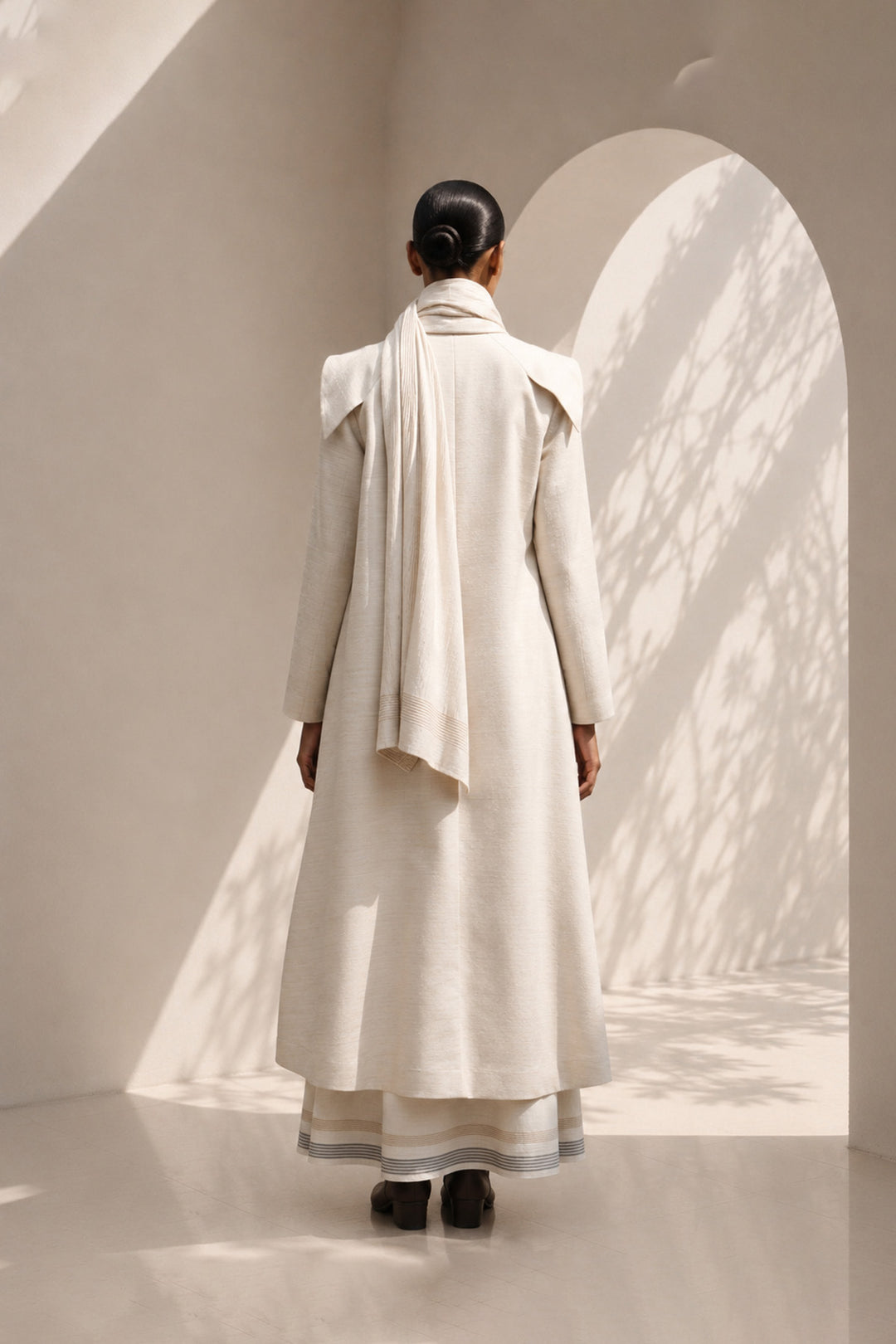 Ivory ensemble featuring oversized lapel collar, structured fit and fluid drape.