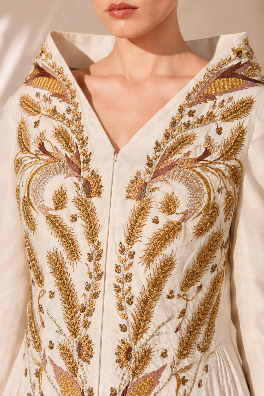 Ivory high-low gown enriched with regal gold embroidery and dramatic layered drapes