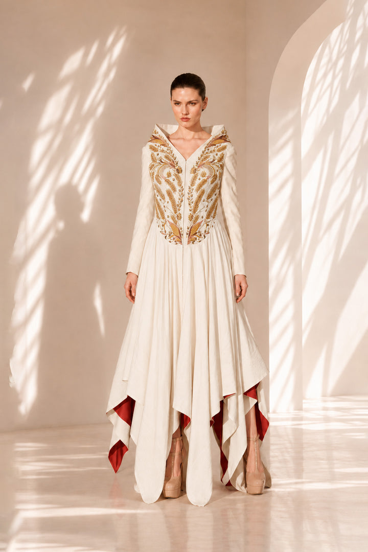 Ivory high-low gown enriched with regal gold embroidery and dramatic layered drapes