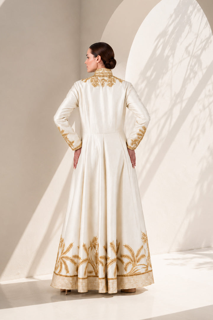 Ivory floor-length gown adorned with full-length sleeves and intricate gold-toned palm-inspired embroidery.