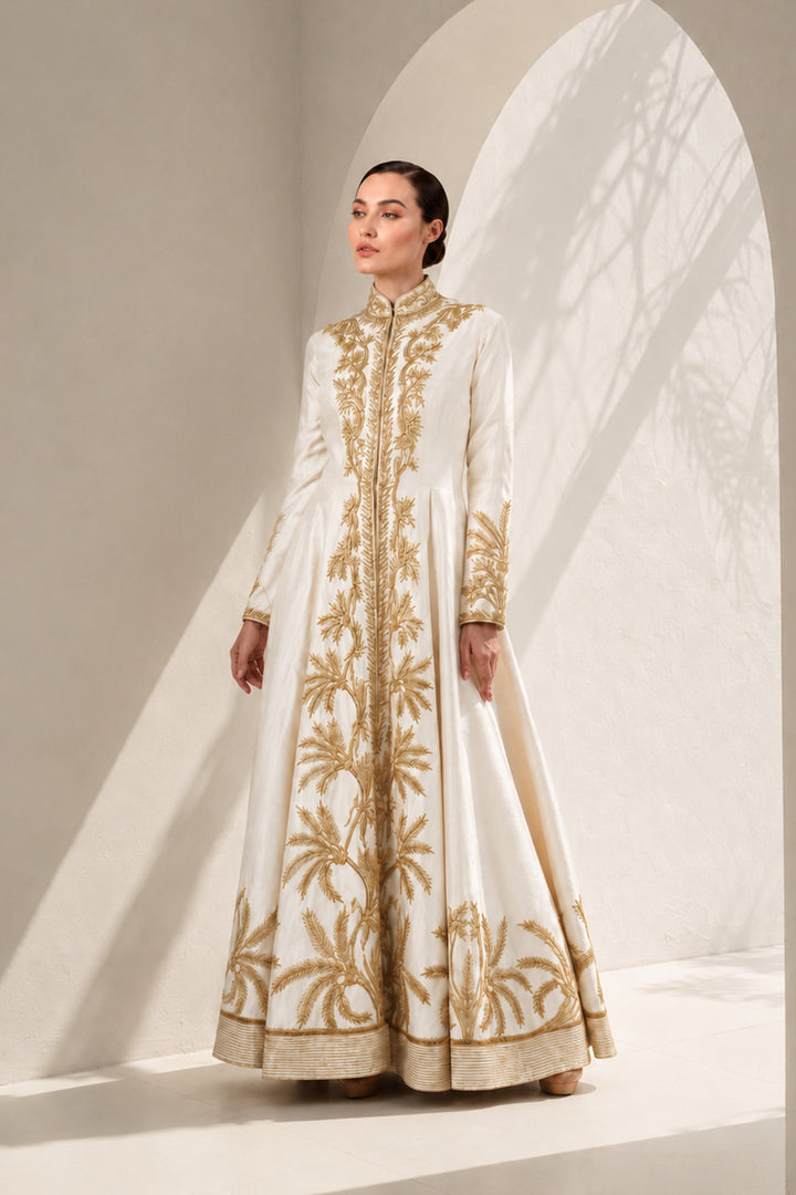 Ivory floor-length gown adorned with full-length sleeves and intricate gold-toned palm-inspired embroidery.
