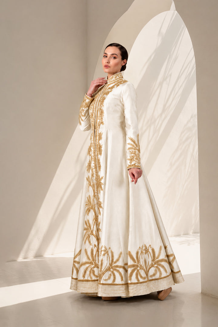 Ivory floor-length gown adorned with full-length sleeves and intricate gold-toned palm-inspired embroidery.