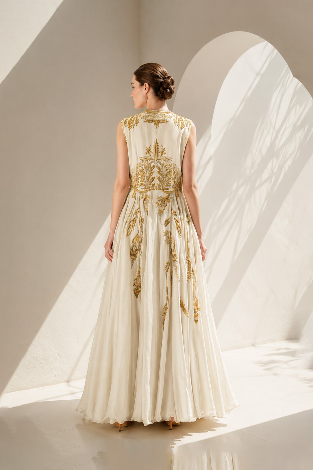 Ivory gown adorned with intricate golden botanical embroidery &amp; graceful drape.
