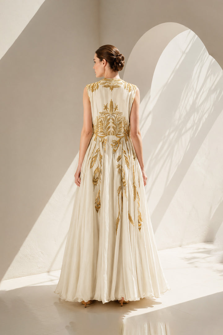 Ivory gown adorned with intricate golden botanical embroidery &amp; graceful drape.