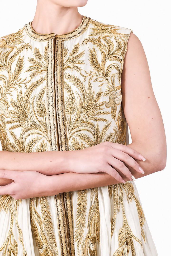 Ivory gown adorned with intricate golden botanical embroidery &amp; graceful drape.