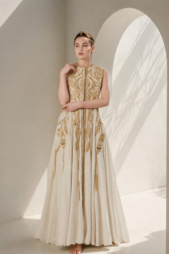 Ivory gown adorned with intricate golden botanical embroidery &amp; graceful drape.