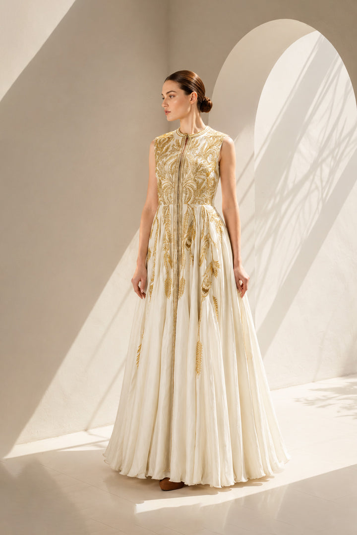 Ivory gown adorned with intricate golden botanical embroidery &amp; graceful drape.