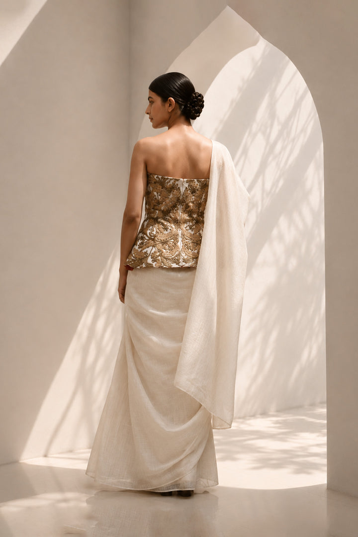 Ivory ensemble featuring structured embroidered peplum bodice, and sheer flowing draped saree.