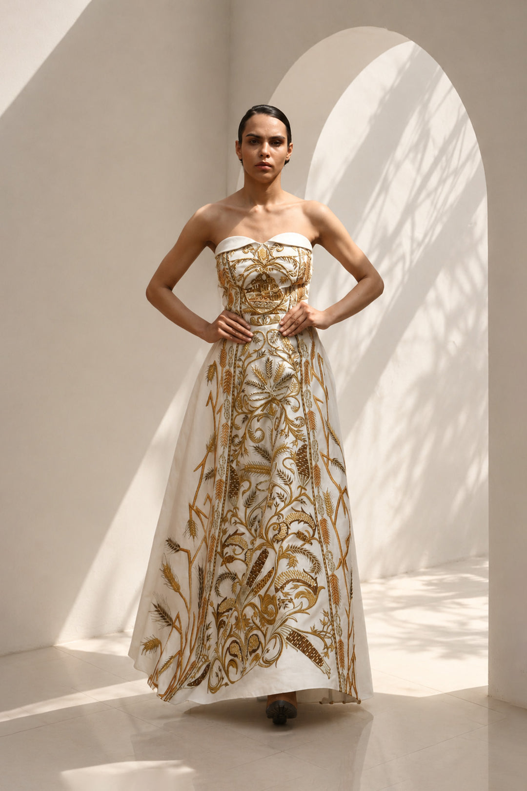 Ivory strapless sweetheart neckline statement gown enriched with gold embroidery.