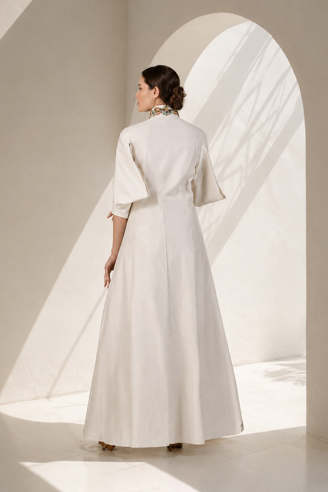 Ivory statement jacket gown adorned with vibrant floral embroidery, elegant high-neck collar detailing and tailored bodice with flatering fit.