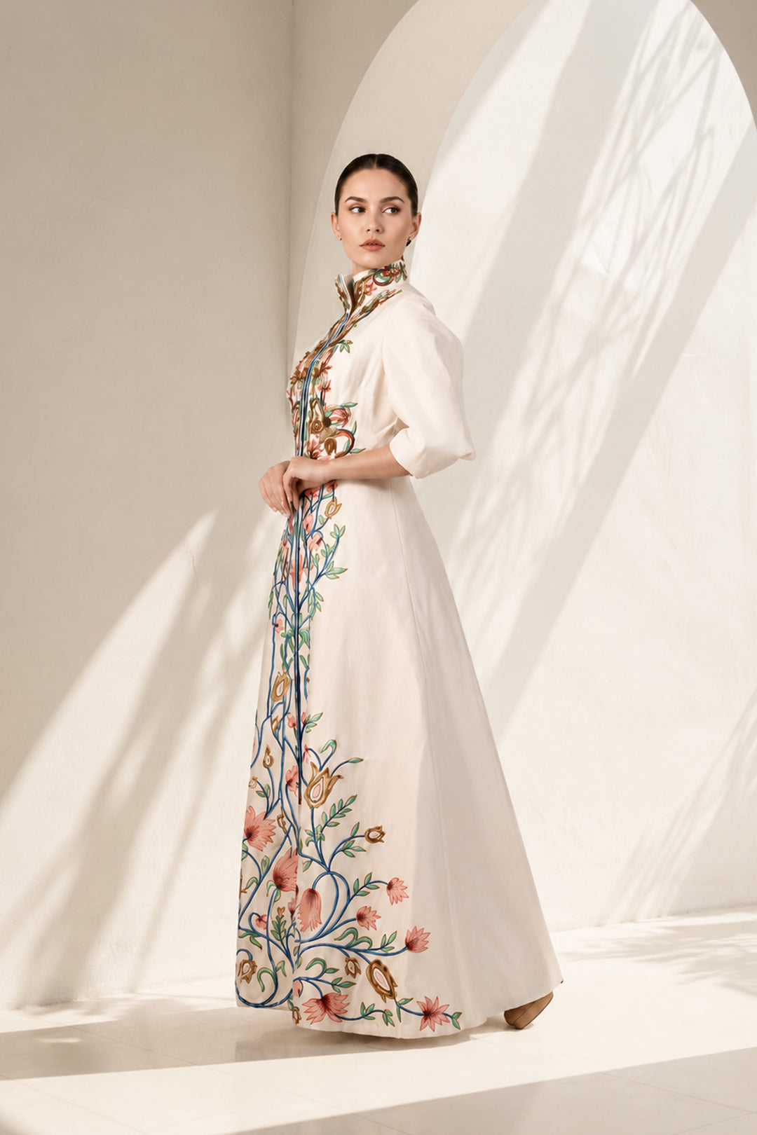 Ivory statement jacket gown adorned with vibrant floral embroidery, elegant high-neck collar detailing and tailored bodice with flatering fit.
