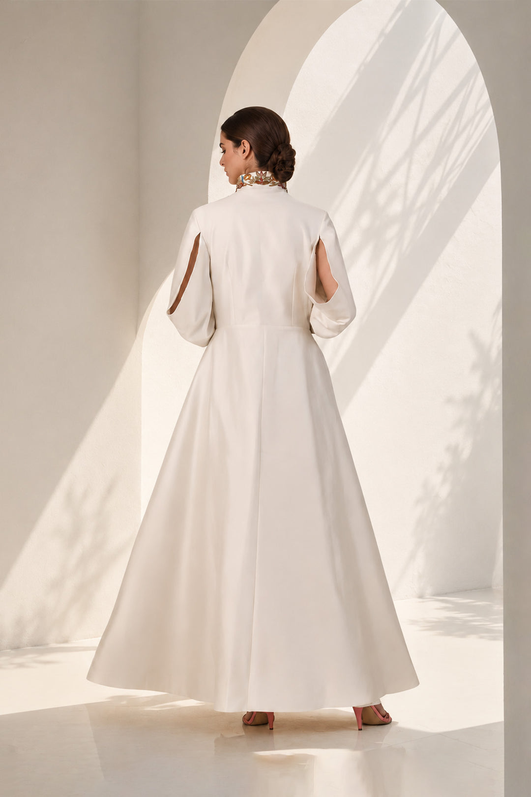 Ivory striking coat gown featuring statement handcrafted embroidery, a sculpted high stand collar with concealed front closure , three-quarter sleeves, &amp; graceful flared silhouette.