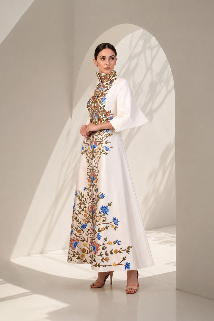 Ivory striking coat gown featuring statement handcrafted embroidery, a sculpted high stand collar with concealed front closure , three-quarter sleeves, &amp; graceful flared silhouette.