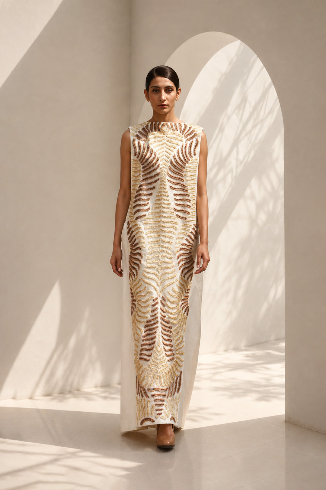 Ivory column dress elevated with intricate nature-inspired embroidery, creating a striking balance of minimalism and artisanal detail.
