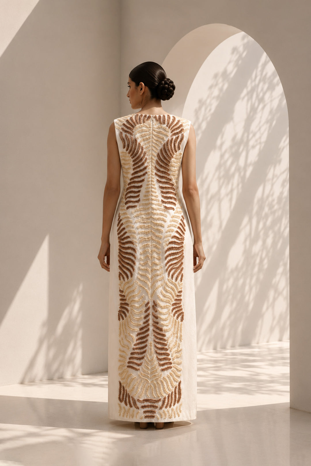 Ivory column dress elevated with intricate nature-inspired embroidery, creating a striking balance of minimalism and artisanal detail.