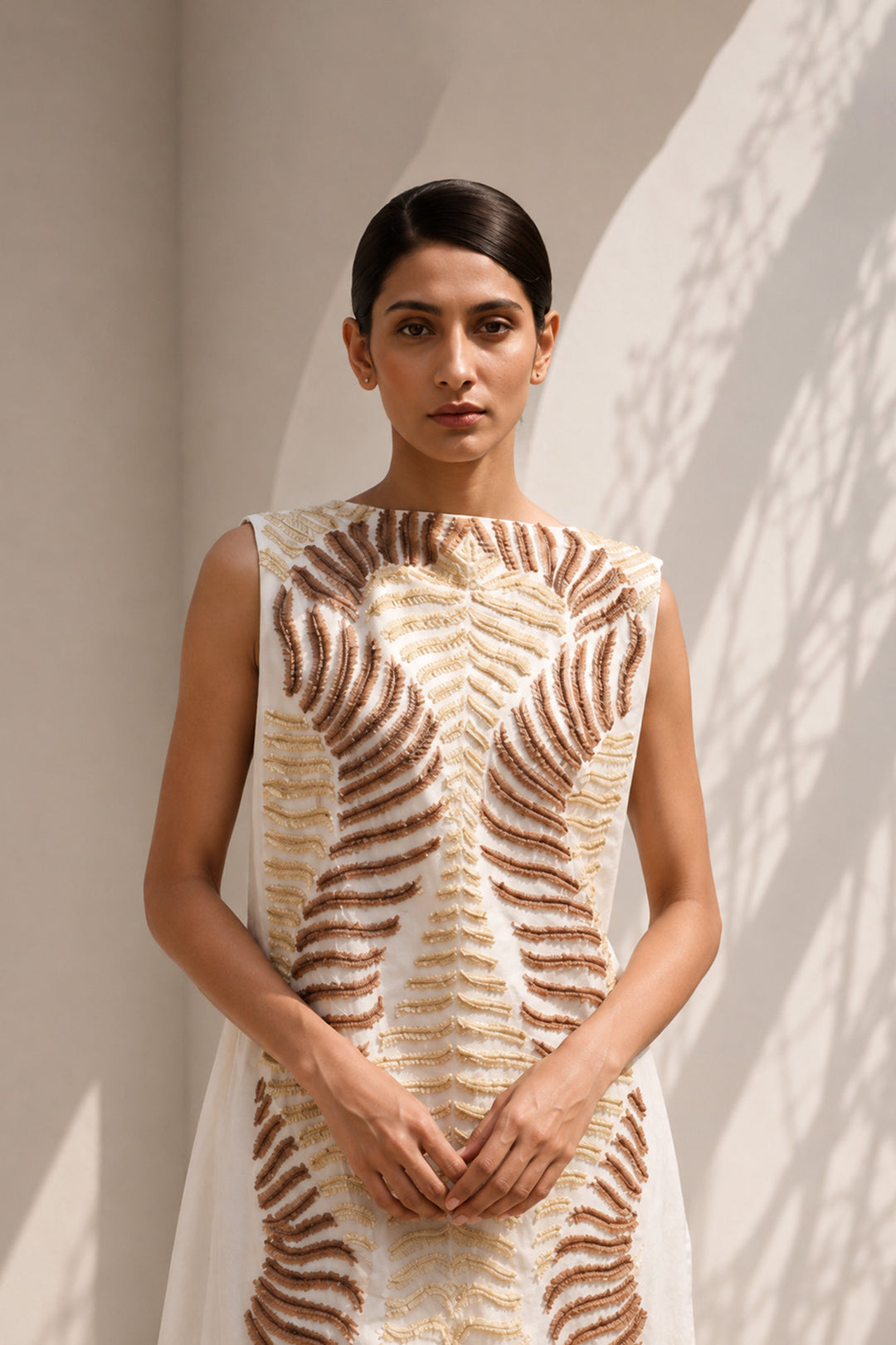 Ivory column dress elevated with intricate nature-inspired embroidery, creating a striking balance of minimalism and artisanal detail.