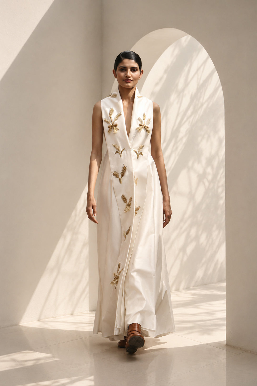 Ivory wrap-inspired gown featuring deep lapel neckline , delicate wheat motif embroidery &amp; blending understated luxury with timeless sophistication.