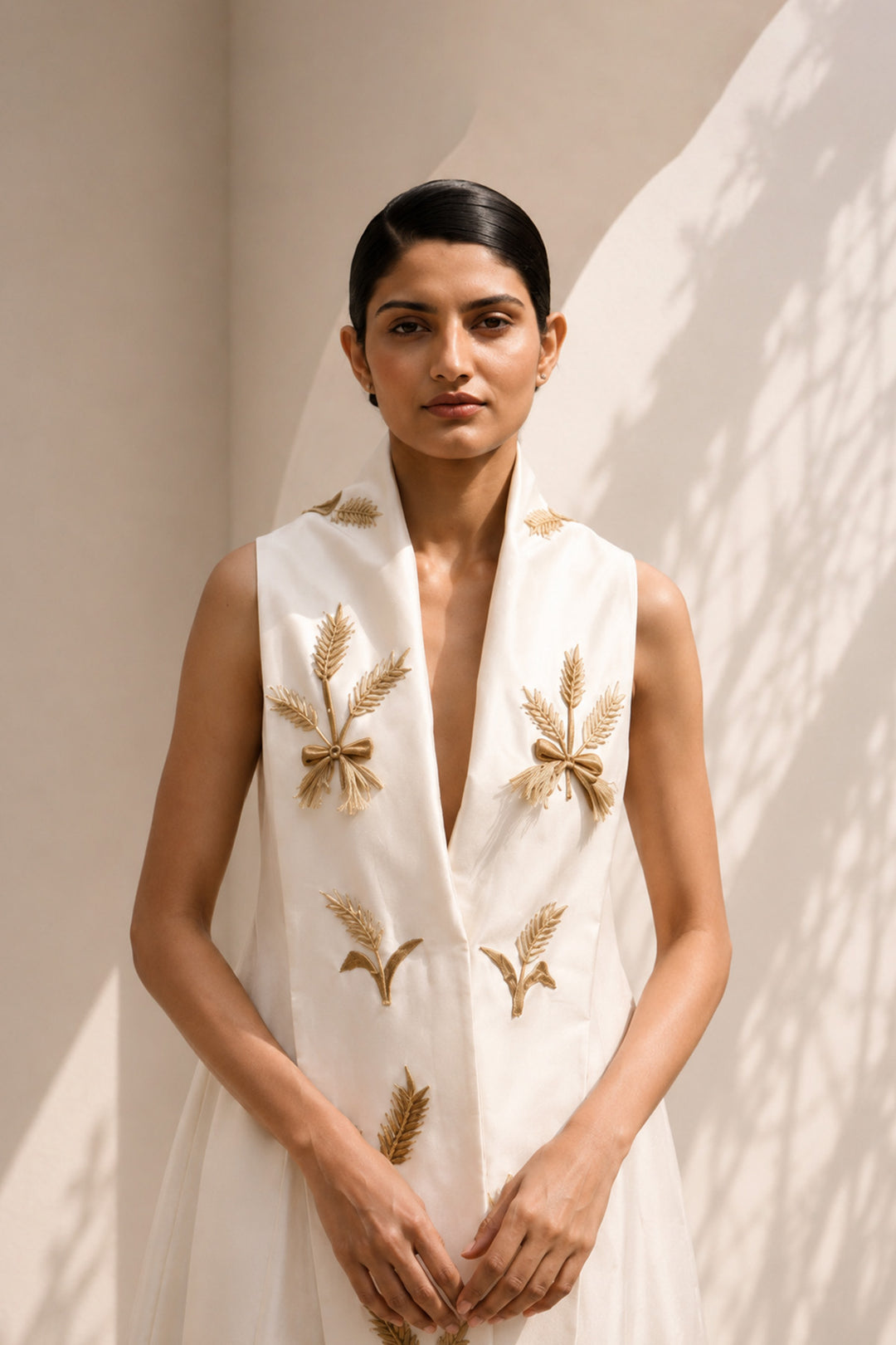 Ivory wrap-inspired gown featuring deep lapel neckline , delicate wheat motif embroidery &amp; blending understated luxury with timeless sophistication.