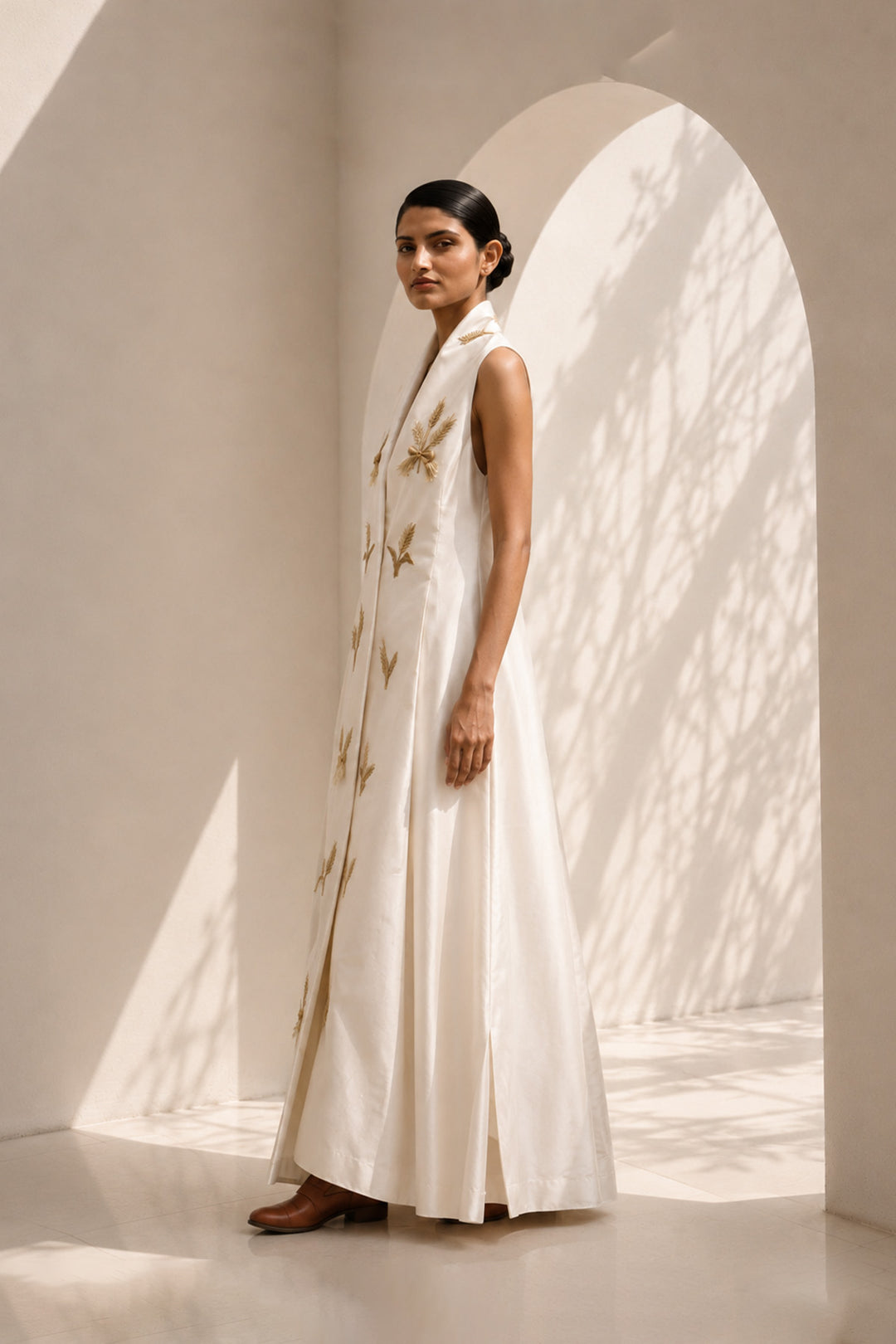 Ivory wrap-inspired gown featuring deep lapel neckline , delicate wheat motif embroidery &amp; blending understated luxury with timeless sophistication.