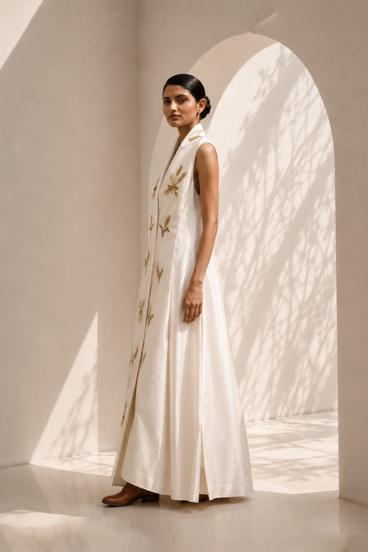 Ivory wrap-inspired gown featuring deep lapel neckline , delicate wheat motif embroidery &amp; blending understated luxury with timeless sophistication.